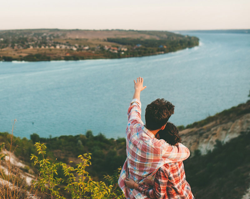 man and woman looking at the ocean